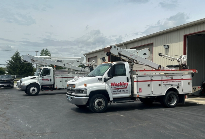 COMMERCIAL ELECTRICAL Weekley Electric commercial service trucks parked outside electrical company facility in Central Ohio.