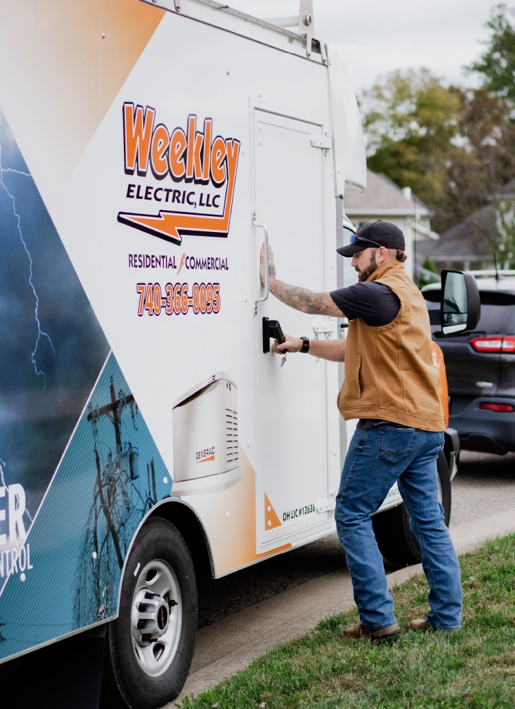 weekley-electric-commercial-generator-service-technician Weekley Electric technician accessing a commercial generator service trailer in Central Ohio.